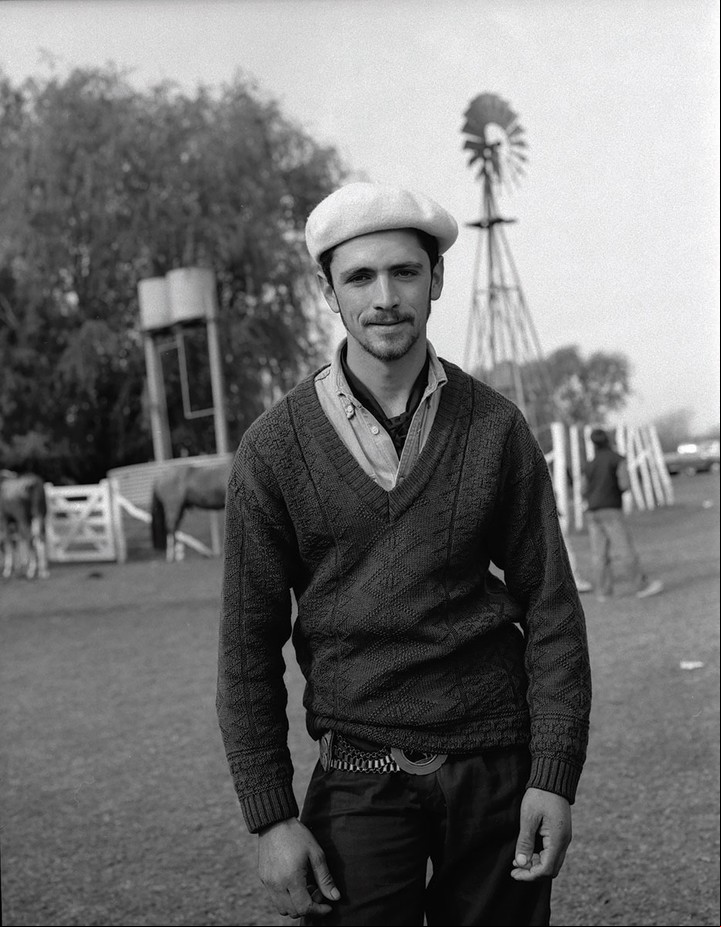 Delante del molino. Un gaucho sonríe.