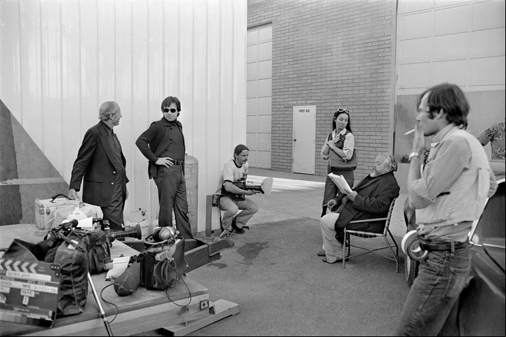 Peter Bogdanovich, segundo de la izquierda, y Orson Welles, en la silla, durante la filmación de "Al otro lado del viento". Foto/ Netflix.