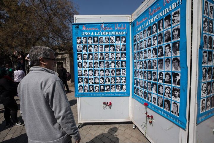 Un hombre observa fotografías de víctimas de la dictadura, en 2019 en Santiago de Chile, tres días antes de que se cumplan 46 años del golpe de EFE/Alberto Valdes