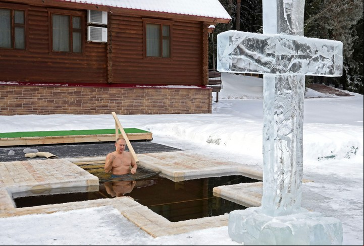 El presidente ruso Vladimir Putin se persigna mientras se sumerge en las aguas heladas durante la celebración de la festividad de la Epifanía en la región de Moscú el 19 de enero de 2021. (Foto de Mikhail KLIMENTYEV / SPUTNIK / AFP)