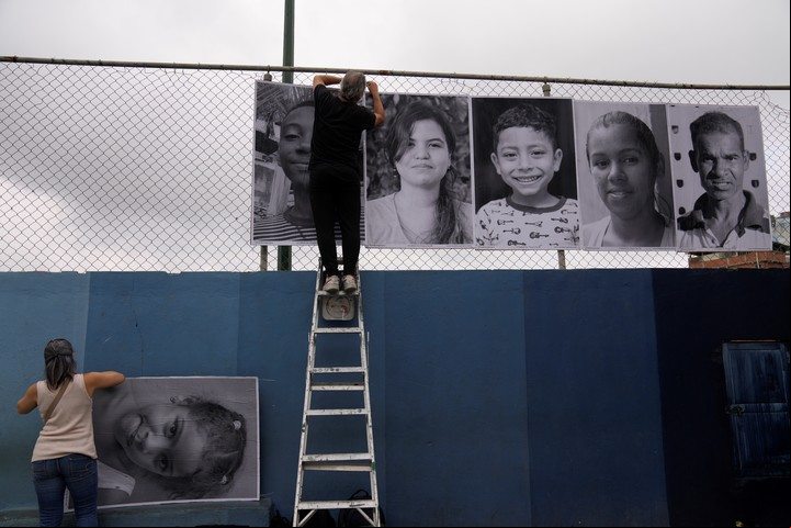 Voluntarios ayudan a instalar las imágenes. Foto AP/ Ariana Cubillos