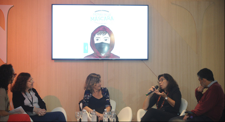 "Detrás de la máscara", el libro sobre la pandemia que escribió Andrea Ferrari pasa por la pantalla mientras Cecilia Pisos, Sandra Comino y Mario Méndez conversan en el Espacio Ñ/Clarin de la Feria del Libro. Foto: Germán García Adrasti.
