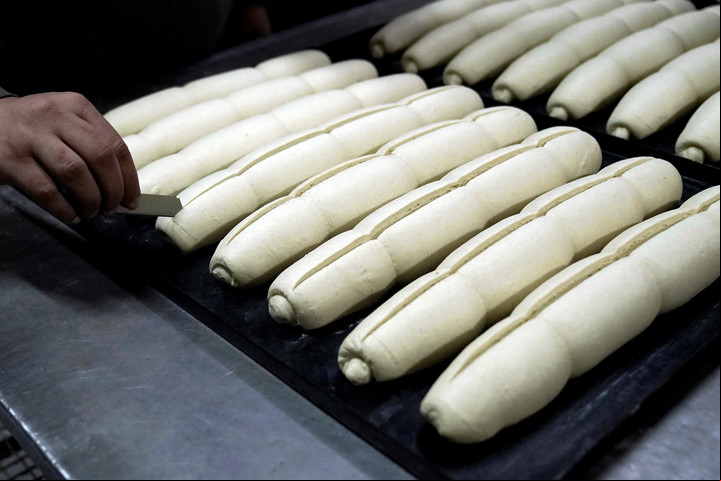 Un panadero termina una bandeja de pan francés antes de meterla en el horno en la panadería Rolón de Parque Patricios. Foto: Fernando de la Orden