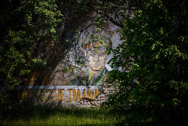 TOPSHOT - Una fotografía muestra un mural en la pared de un edificio fantasma en un bosque dentro de la Zona de Exclusión de Chernóbil el 29 de mayo de 2022. (Foto de Dimitar DILKOFF / AFP)