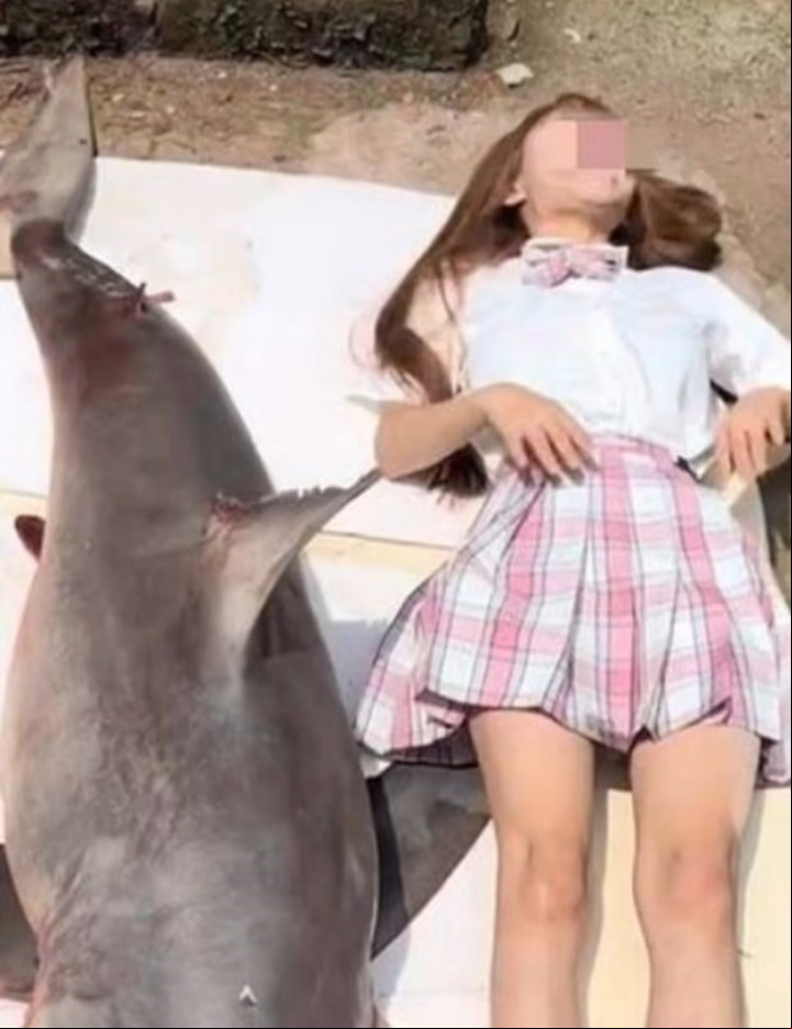 La mujer junto al tiburón capturado de 50 kilos (Captura de video).