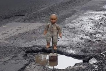 Cansados de los baches, vecinos colocan un aterrador bebé de juguete como señal de alerta