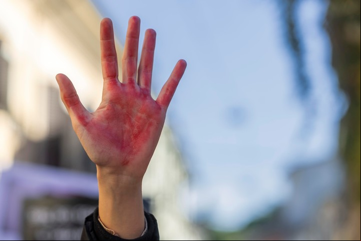 Una mano manchada de rojo sangre, como símbolo de la violencia contra las mujres, en una marcha en Ravenna, Italia. Foto: EFE