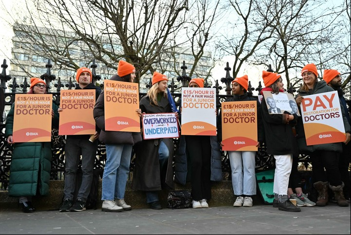 Jóvenes médicos protestan con carteles en reclamo de mejoras salariales, frente a un hospital en Londres. Foto: AFP