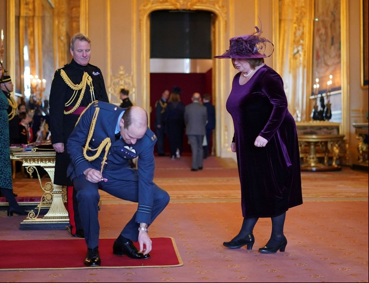 William recoge el premio del piso para Suzanne Hutchinson, de una organización de caridad, galardonada como miembro de Honor del Imperio Británico. Foto: AP
