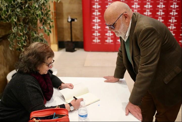 La escritora firmando ejemplares. Cónclave inesperado en el Cervantes, con su primo, de la galería rosarina Diego Obligado. Foto Cezaro de Luca. / Archivo Clarín