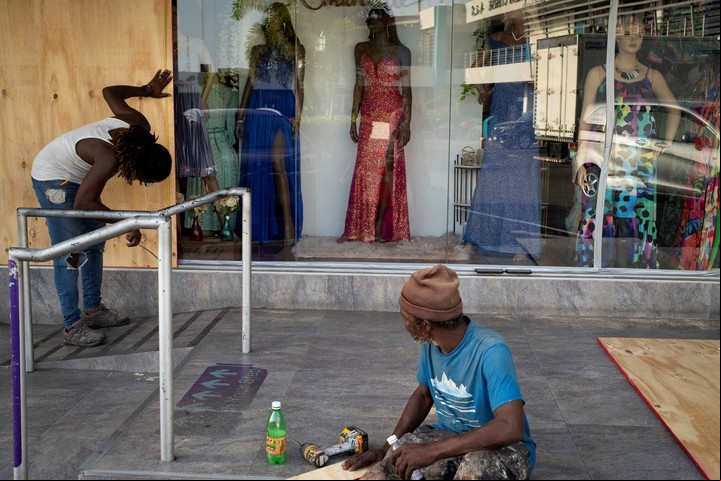 Empleados tapan vitrinas de negocios en Jamaica. Foto: Reuters