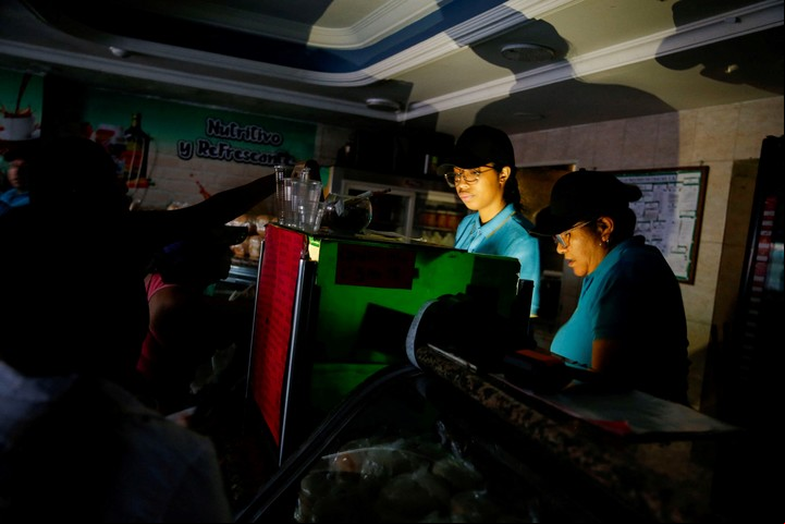 Dos empleadas trabajan en un local de comidas en Caracas. Foto: Reuters/Leonardo Fernandez Viloria.