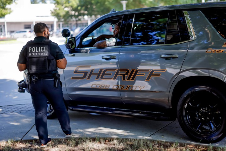 Un oficial del Servicio Secreto de EE.UU. habla con un policía que custodia el local de un acto en el que hablan el presidente Joe Biden y la vice y candidata Kamala Harris, este viernes. Foto: EFE
