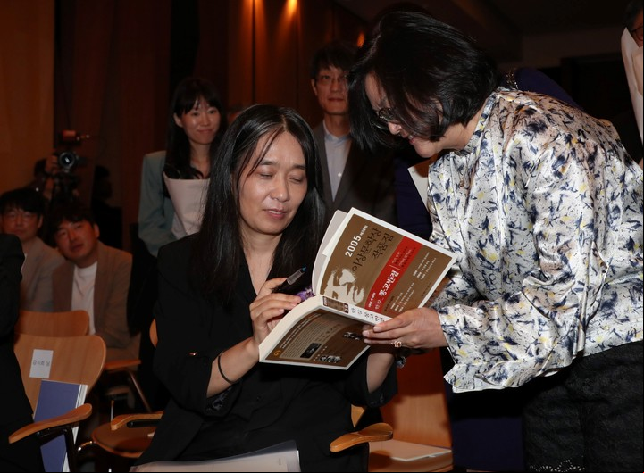 Han Kang (C) firma un libro durante la ceremonia de entrega del Premio a la Innovación Pony Chung, en Seúl, Corea del Sur(Corea del Sur, Seúl) EFE/EPA/KOREA POOL COREA OUT