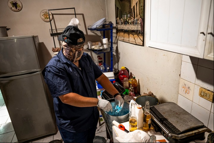 Un cocinero del cártel de Sinaloa mezclando colorante azul en un cubo de polvo de fentanilo. Foto de Meridith Kohut para The New York Times.