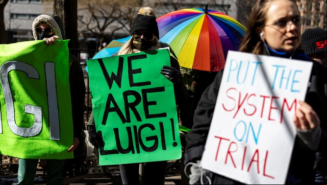 Carteles con frases como "Todos somos Luigi" y "Procesen al sistema" reflejan la narrativa que apoya a Mangione y rechaza al sistema de salud estadounidense. Foto: EPA/Justin Lane