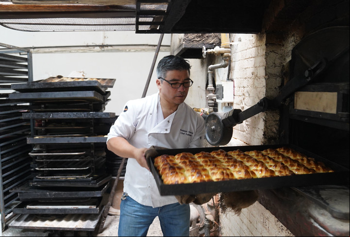 Héctor hornea las medialunas en el horno histórico. Foto: Guillermo Rodriguez Adami.