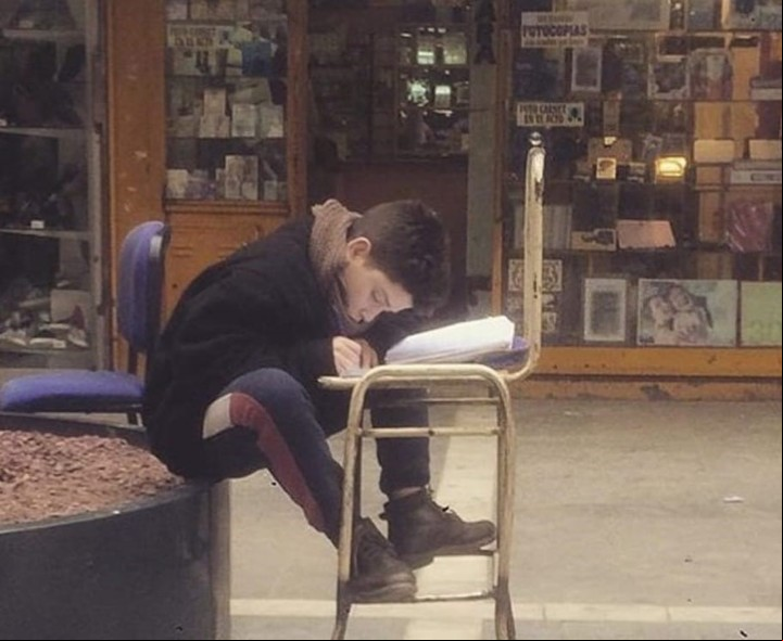 Angelo Barrera estudiando en la peatonal de Córdoba mientras sus papás vendían medias. Foto Archivo