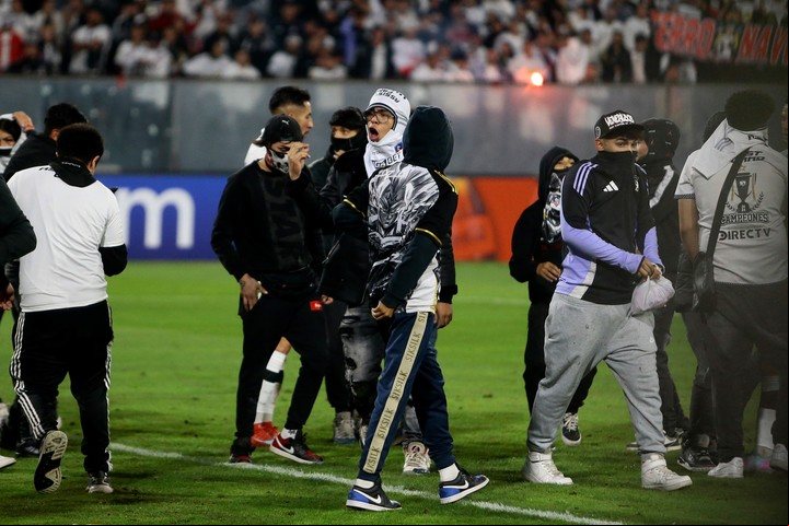 Los barras de Colo Colo invaden el campo para suspender el partido. Foto: EFE / Osvaldo Villarroel.