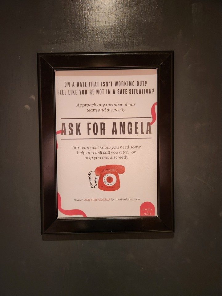 Los negocios que participan del programa "Ask for Angela" anuncian con posters que su personal está preparado para ayudar a las personas que se sientan inseguras. El programa nació en 2016 en el Reino Unido en memoria de Angela Phillips, vícitma mortal de violencia de género.