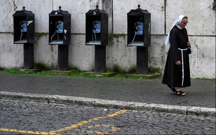 Una monja camina junto a unas cabinas telefónicas en la Ciudad del Vaticano, este lunes. Foto EFE/ Riccardo Antimiani
