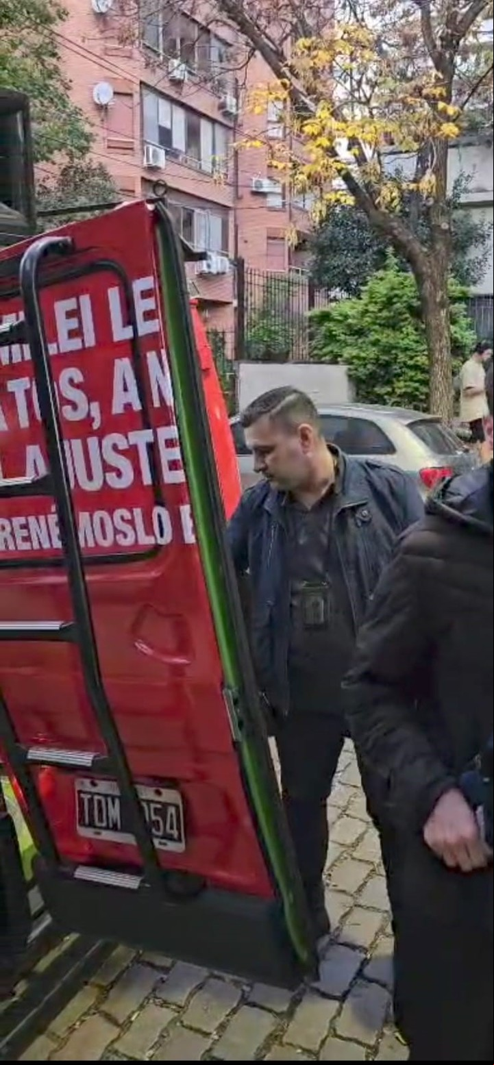 Uno de los oficiales de la Unidad Antiterrorista que detuvieron a los militantes de Lula Levy revisa la camioneta de la campaña de Evolución.