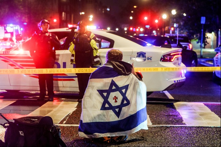 Un hombre con una bandera israelí cerca del lugar donde dos personas fueron asesinadas. Foto: EFE